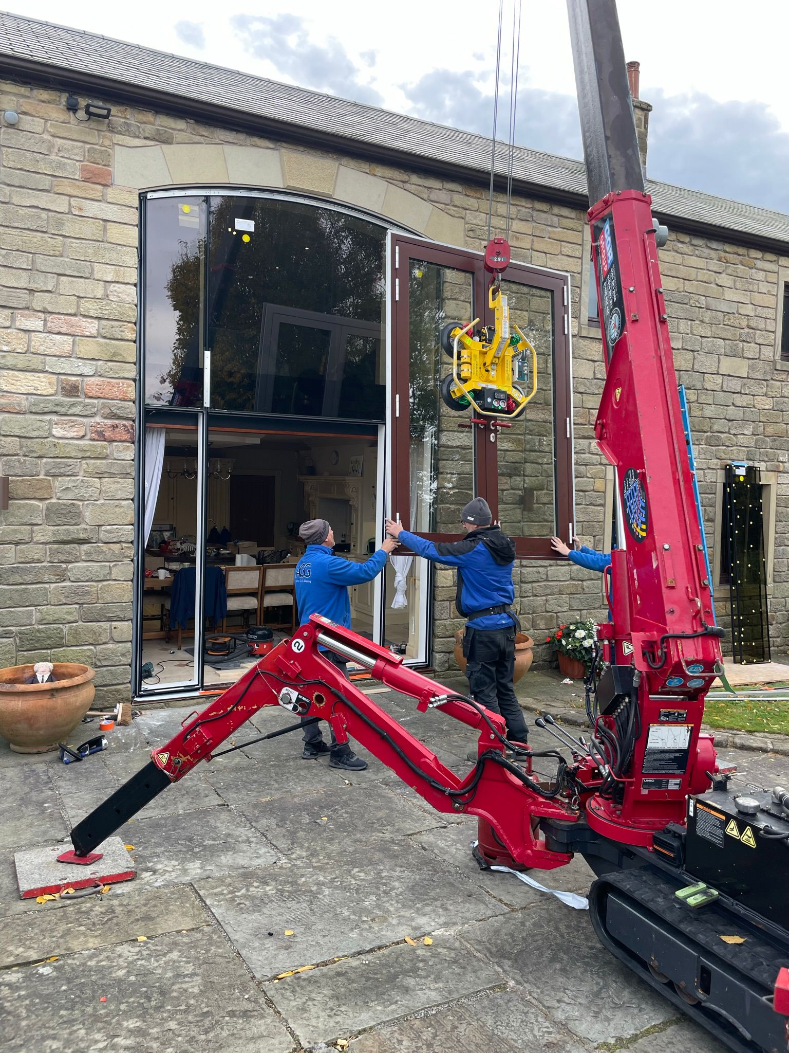 Glazed curtain wall - AGG team moving door into position